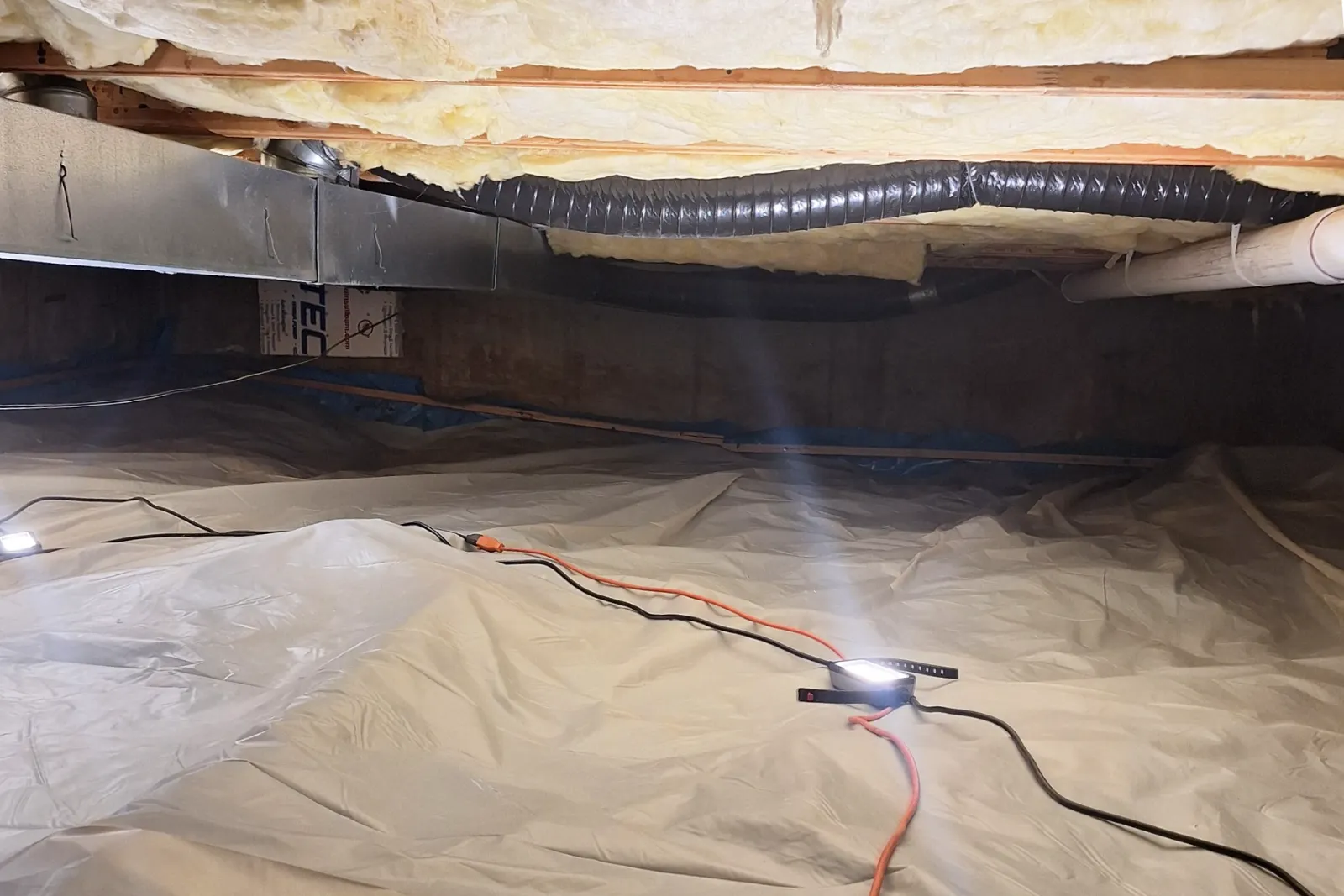 Crawl space after mold remediation with clean wood framing and moisture control improvements